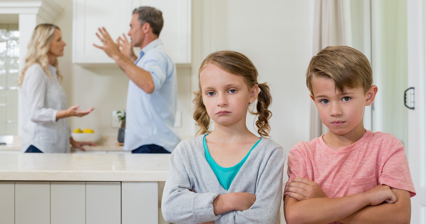 Sad sibling standing with arms crossed while parents arguing each other
